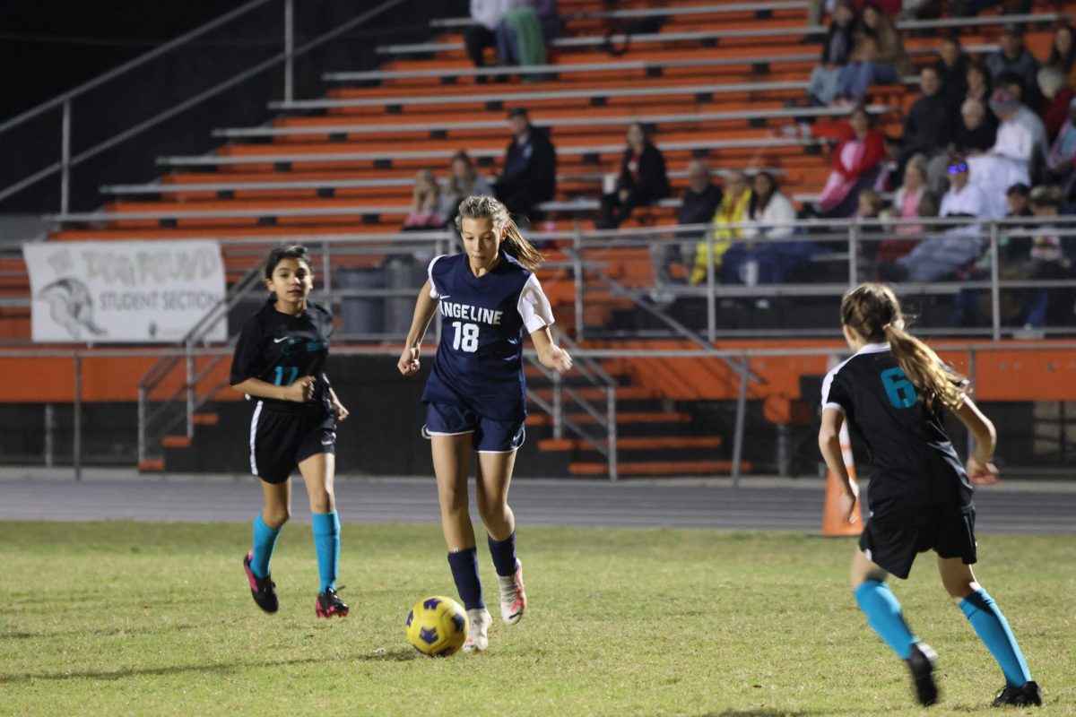 Mya Stapleton dribbles past the defenders looking for an opportunity to score.